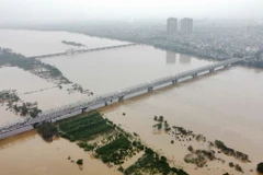 Mực nước bắt đầu hạ, các phương tiện lưu thông trên cầu Chương Dương an toàn (ảnh chụp sáng 12/9). (Ảnh: Hoàng Hiếu/TTXVN)