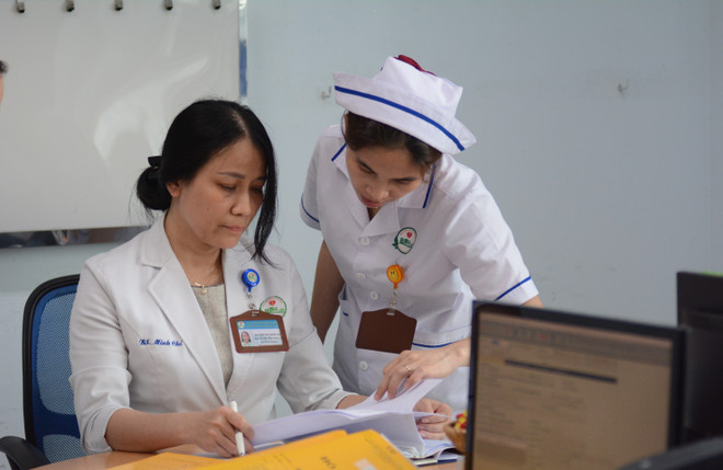 Bác sỹ Nguyễn Thị Minh Chí trao đổi công việc với nhân viên y tế. (Ảnh: Văn Dũng/TTXVN) bac-sy-3.jpg