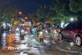 Các phương tiện di chuyển khó khăn khi triều cường gây ngập trên đường Trần Xuân Soạn (Quận 7, Thành phố Hồ Chí Minh). (Ảnh: Hồng Giang/TTXVN) 