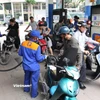 Nhân viên Petrolimex bán xăng cho khách hàng. (Ảnh: Đức Duy/Vietnam+)