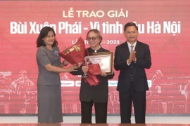 Phó Tổng giám đốc TTXVN Nguyễn Thị Sự và Phó Chủ tịch UBND Thành phố Hà Nội Hà Minh Hải trao giải thưởng lớn - Vì tình yêu Hà Nội cho Nghệ sỹ Nhân dân, đạo diễn Đặng Nhật Minh. (Ảnh: Minh Quyết/TTXVN)