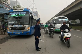 Lực lượng Thanh tra giao thông Vận tải Hà Nội xử lý xe dừng, đón trả khách sai quy định. (Ảnh: Việt Hùng/Vietnam+)