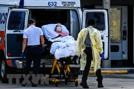 Nhân viên y tế chuyển bệnh nhân nhiễm COVID-19 tới bệnh viện ở Miami, Mỹ. (Ảnh: AFP/TTXVN) 