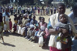 Các bà mẹ đưa con nhỏ đi tiêm vaccine phòng sởi tại Harare, Zimbabwe. (Ảnh: AFP/TTXVN)