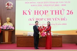 Bí thư Tỉnh ủy Quảng Ngãi Bùi Thị Quỳnh Vân tặng hoa tân Chủ tịch Ủy ban Nhân dân tỉnh Nguyễn Hoàng Giang (trái). (Ảnh: Phạm Cường/TTXVN)