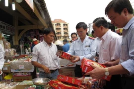 Đoàn Thanh tra Bộ Y tế và thanh tra liên ngành Thành phố Hồ Chí Minh kiểm tra bánh mứt Tết tại chợ Bình Tây. (Ảnh: Phương Vy/TTXVN)