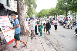 Người dân xếp hàng nhận suất ăn hỗ trợ. (Ảnh: CTV/Vietnam+)