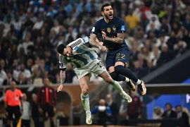 Pha tranh bóng bổng quyết liệt giữa hậu vệ Pháp Theo Hernandez (phải) và tiền đạo Argentina Messi trong trận chung kết World Cup 2022. (Ảnh: AFP/TTXVN)