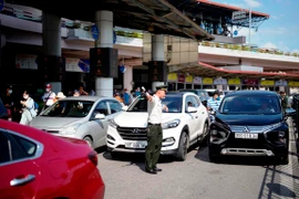 Nhân viên an ninh hàng không phân làn phương tiện đi vào làn đỗ tại Nhà ga T1 Sân bay Quốc tế Nội Bài. (Ảnh: CTV/Vietnam+