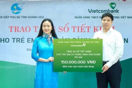 Ông Hồng Quang - Thành viên HĐQT kiêm Giám đốc Khối nhân sự, Chủ tịch Công đoàn Vietcombank trao biểu trưng 150 triệu đồng cho bà Nguyễn Quỳnh Nga - Chủ tịch Hội Liên hiệp Phụ nữ tỉnh Khánh Hòa. (Ảnh: Vietnam+)