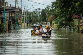 Người dân Indonesia sơ tán khỏi khu vực ngập lụt ở Gresik, Đông Java ngày 15/12/2020. (Ảnh: AFP/TTXVN)